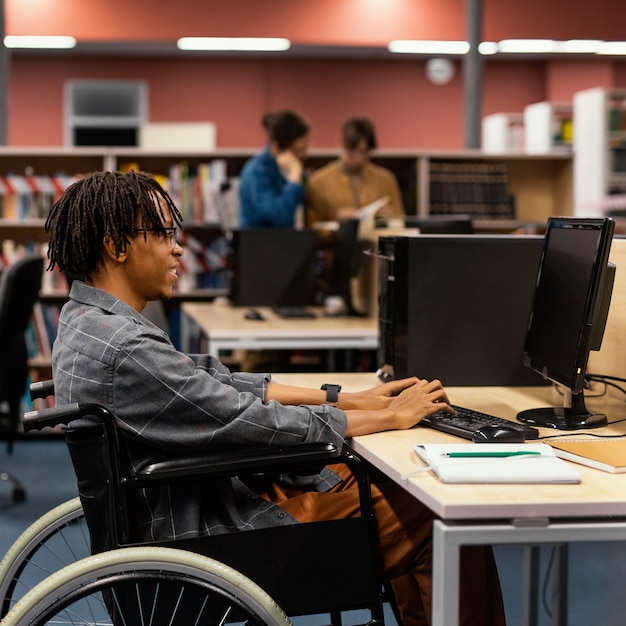 Bezpłatne zdjęcie młody człowiek studiuje w bibliotece uniwersyteckiej