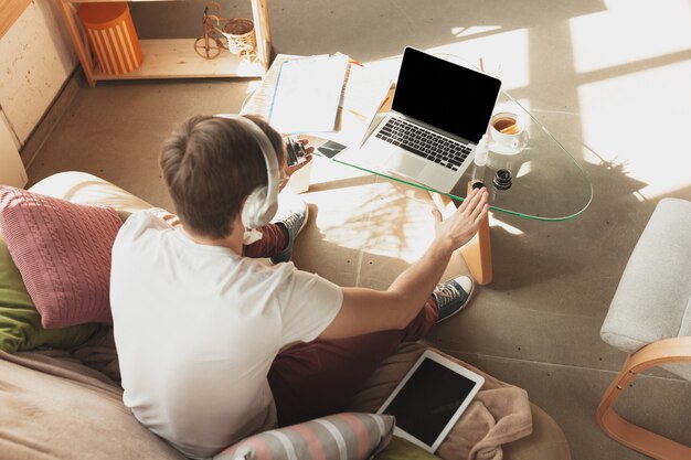 Młody człowiek studiuje w domu podczas kursów online