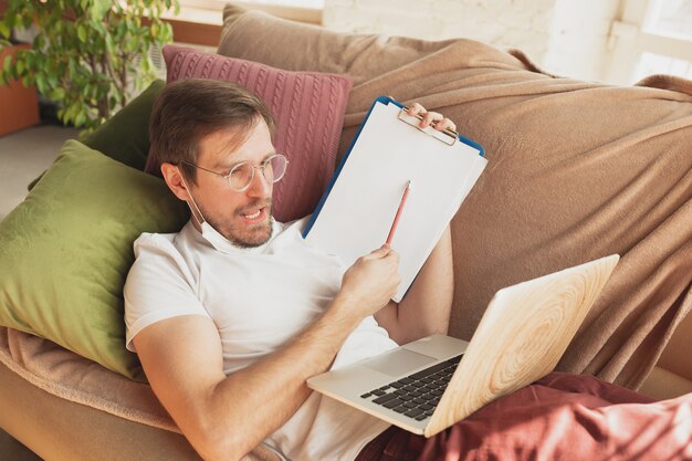Młody człowiek studiuje w domu podczas kursów online