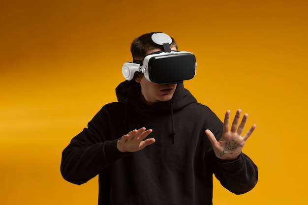 Bezpłatne zdjęcie młody człowiek ubrany w nowoczesne okulary wirtualnej rzeczywistości