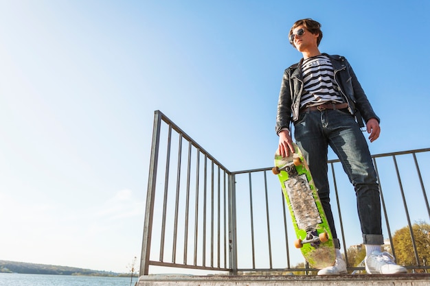 Bezpłatne zdjęcie młody człowiek z jego jeździć na deskorolce w skate parku