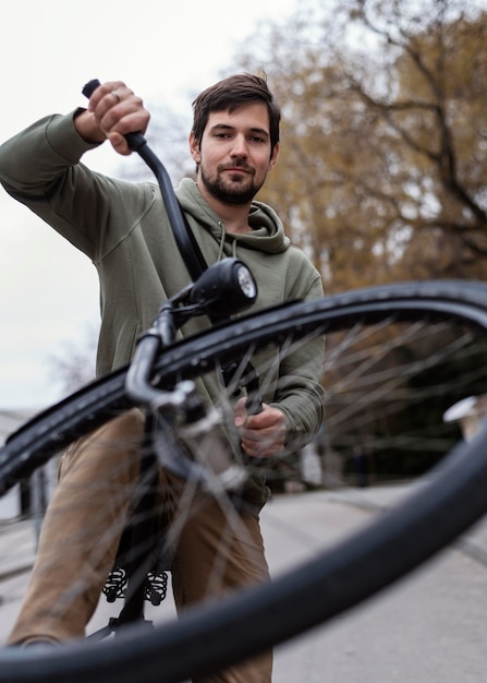 Bezpłatne zdjęcie młody człowiek z rowerem w parku