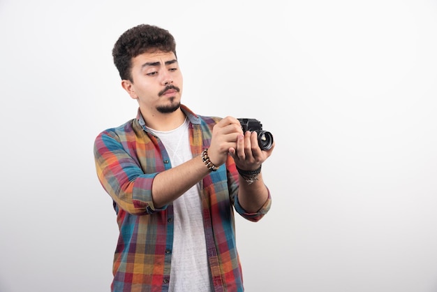 Młody, doświadczony fotograf, robiący profesjonalne zdjęcia w poważny sposób.