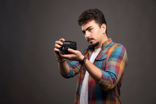 Młody, doświadczony fotograf, robiący profesjonalne zdjęcia w poważny sposób.