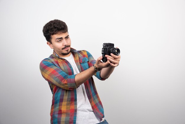 Młody, doświadczony fotograf, robiący profesjonalne zdjęcia w poważny sposób.