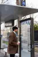 Bezpłatne zdjęcie młody francuz sprawdza mapę dworca autobusowego
