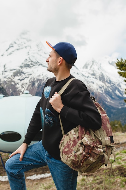 Bezpłatne zdjęcie młody hipster mężczyzna siedzi w górach