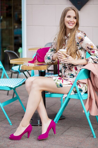 Młody hipster stylowa kobieta siedzi w kawiarni, trend w modzie wiosna lato