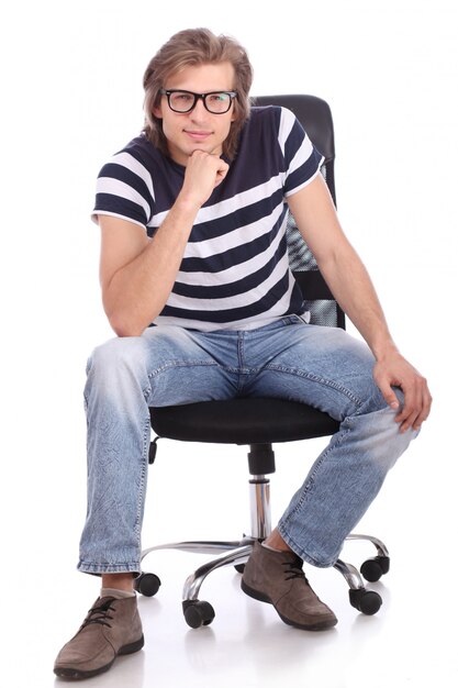 Młody i przystojny facet siedzi na krześle