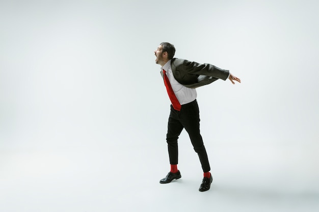 Bezpłatne zdjęcie młody kaukaski mężczyzna porusza się elastyczny na białej ścianie
