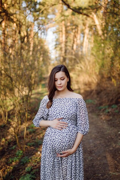 Młody kobieta w ciąży relaksuje w parku outdoors