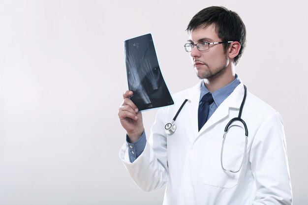 Młody lekarz patrząc na zdjęcie rentgenowskie