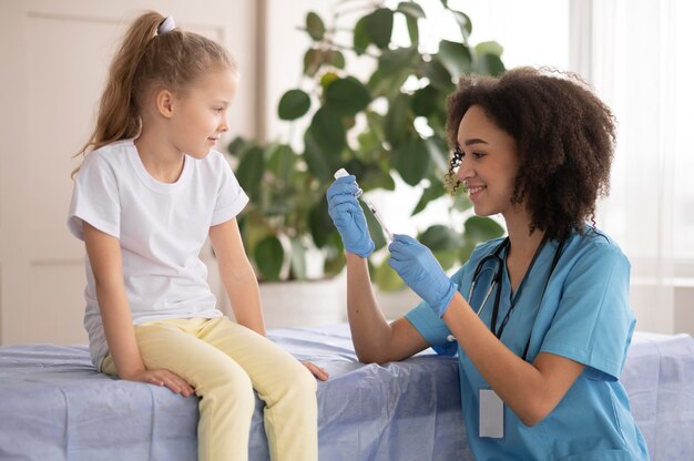 Młody lekarz szczepi małą dziewczynkę