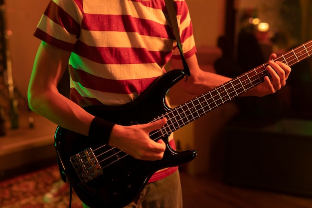 Młody mężczyzna grający na gitarze na lokalnej imprezie