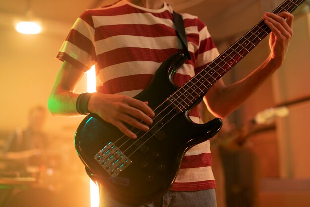 Młody mężczyzna grający na gitarze na lokalnej imprezie