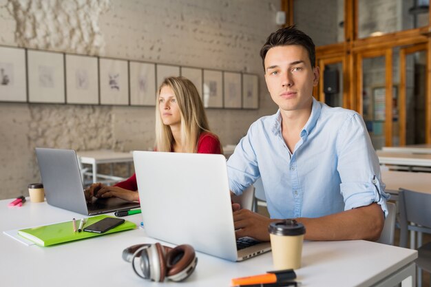 Młody mężczyzna i kobieta pracuje na laptopie w otwartej przestrzeni co-working office room