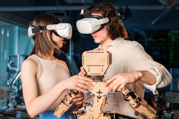 Młody mężczyzna i kobieta w okularach ochronnych robi eksperymenty w robotyce w laboratorium Robot