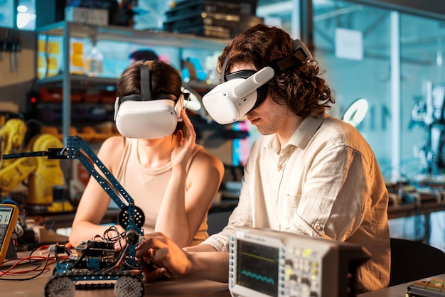Bezpłatne zdjęcie młody mężczyzna i kobieta w okularach vr przeprowadzający eksperymenty w robotyce w laboratorium robot i narzędzia