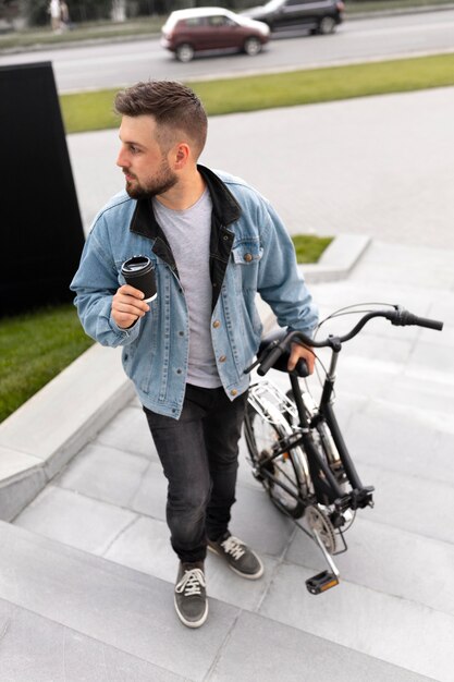 Młody mężczyzna korzystający ze składanego roweru w mieście