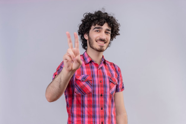 Młody mężczyzna kręcone włosy na białym tle kolorowe koszula dwa palce