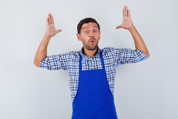 Młody mężczyzna kucharz w niebieskim fartuchu i koszuli