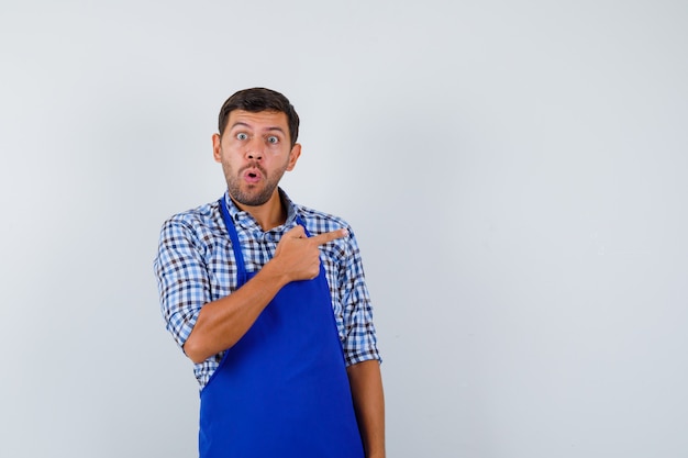 Młody mężczyzna kucharz w niebieskim fartuchu i koszuli