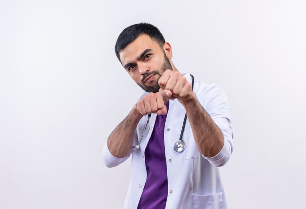 młody mężczyzna lekarz noszenie stetoskop medycznej sukni stojącej w pozie walki na odizolowanej białej ścianie