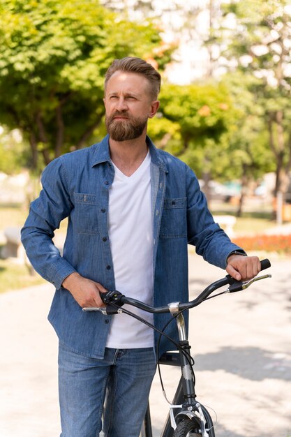 Młody mężczyzna spędzający czas na zewnątrz ze swoim rowerem