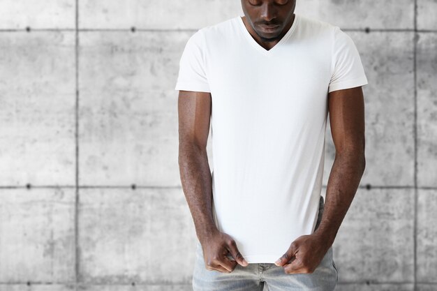Młody mężczyzna sportowe na sobie stylowe dżinsy i białą koszulkę