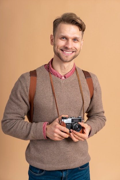 Bezpłatne zdjęcie młody mężczyzna trzyma aparat do podróży