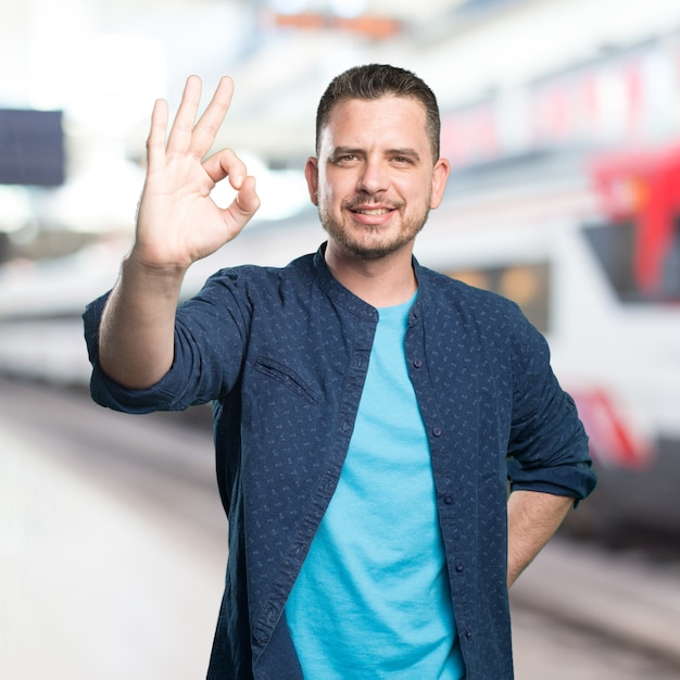 Bezpłatne zdjęcie młody mężczyzna ubrany w niebieski strój. robi ok gest.