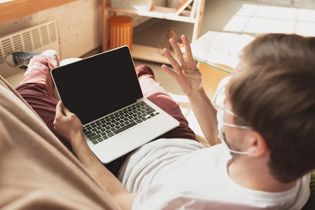Młody mężczyzna uczący się w domu podczas kursów online