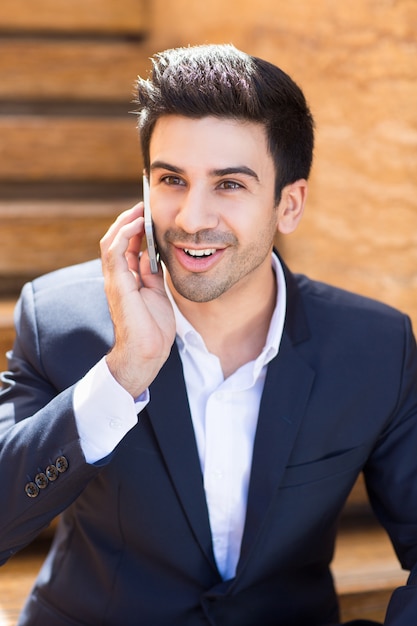 Bezpłatne zdjęcie młody mężczyzna uśmiecha rozmawia przez telefon