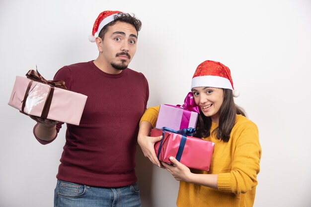Młody mężczyzna z kobietą stwarzających z prezentami świątecznymi.