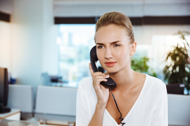 Młody piękny pomyślny bizneswomanu mówienie na telefonie, nad biurem