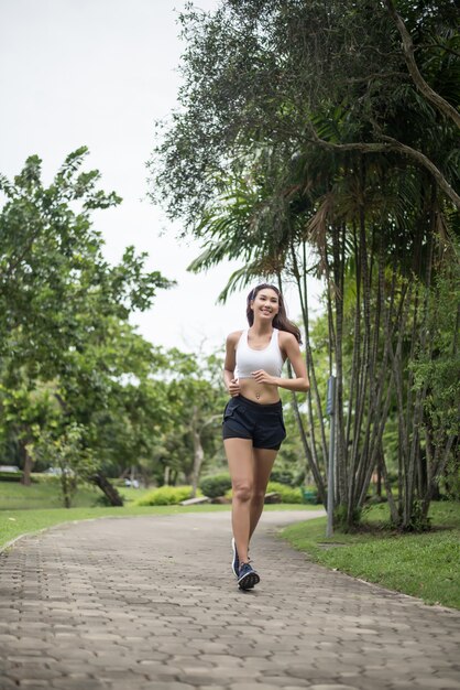 Młody piękny sport kobiety bieg przy parkiem. Koncepcja zdrowia i sportu.