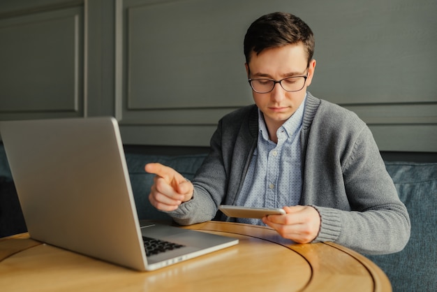 Młody Przystojny Freelancer Wyszukiwanie Ważnych Informacji, Praca Z Nowoczesnym Laptopem