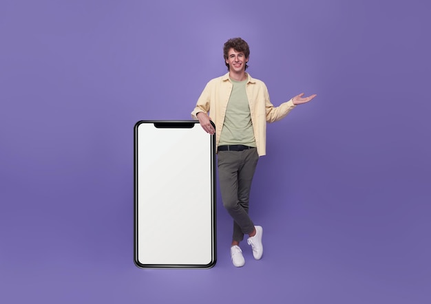 Młody przystojny mężczyzna stojący z makieta duży smartfon pusty biały ekran na fioletowym tle