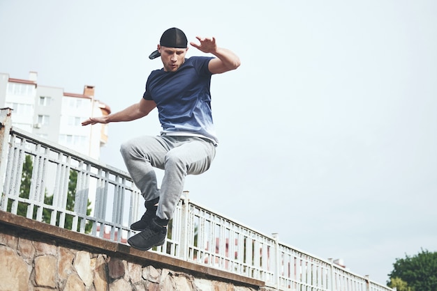 Bezpłatne zdjęcie młody sportowiec robi parkour w mieście.