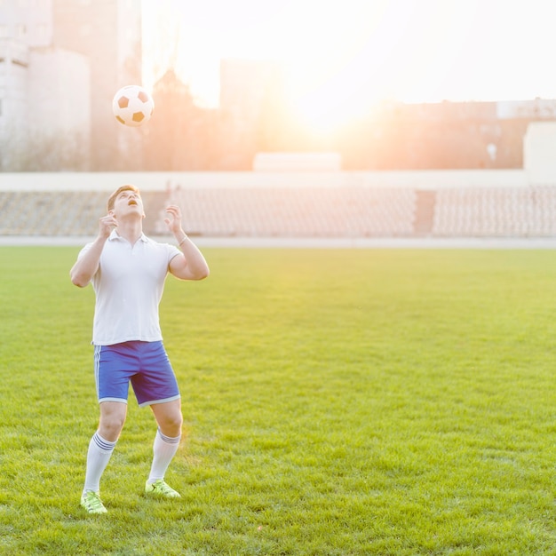 Bezpłatne zdjęcie młody sportowiec rzuca piłkę