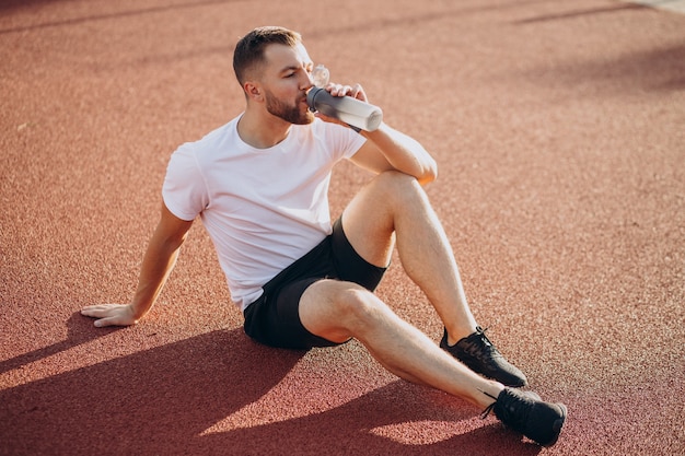 Młody sportowiec wody pitnej na stadionie