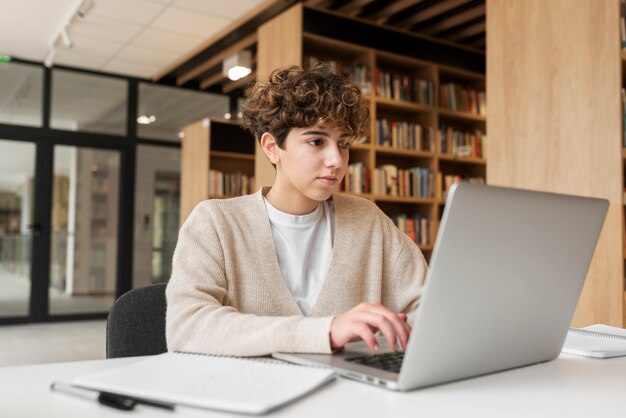 Młody student uczący się w bibliotece