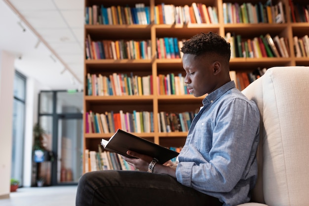 Młody student uczący się w bibliotece