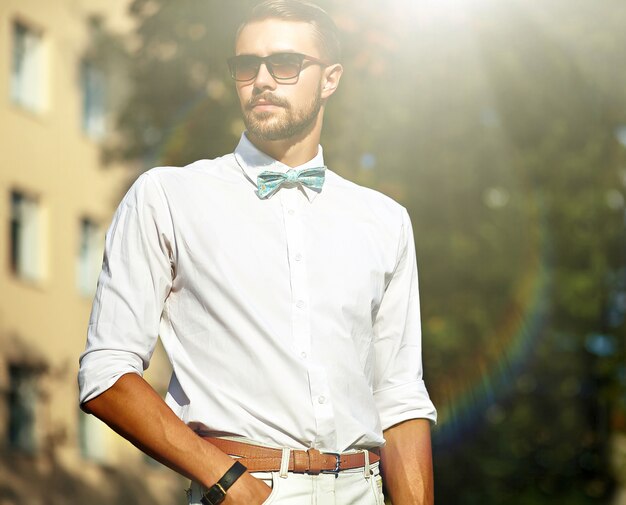 Młody stylowy seksowny przystojny model mężczyzna w stylu casual tkaniny na ulicy w okularach