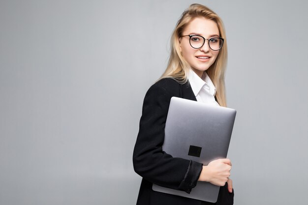 Młody szczęśliwy uśmiechnięty bizneswomanu mienia laptop odizolowywający