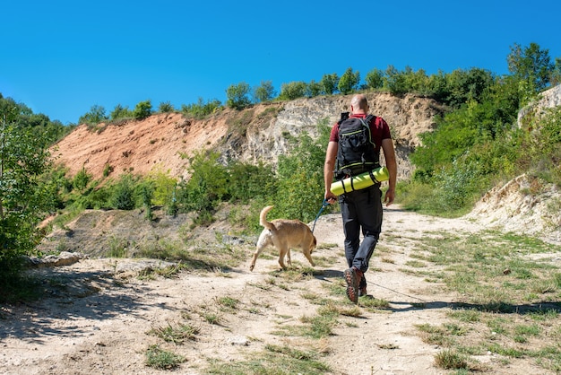 Bezpłatne zdjęcie młody turysta płci męskiej rasy kaukaskiej zwiedzający piękne miejsca ze swoim psem