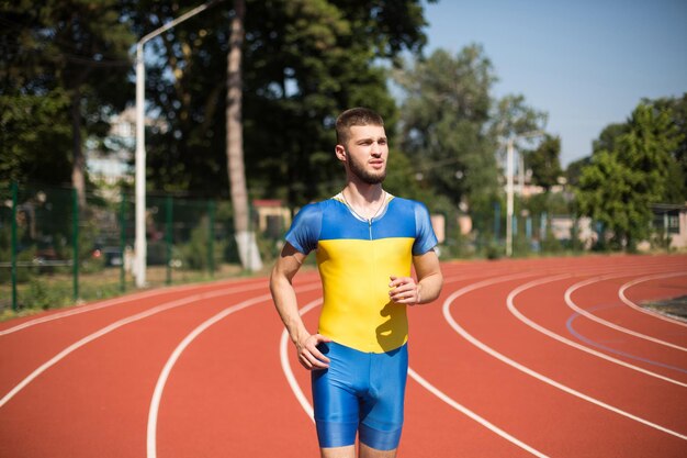 Młody zawodowy sportowiec biegający na bieżni stadionu miejskiego