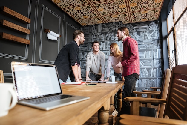 Młodzi atrakcyjni koledzy stoi w biurze i coworking