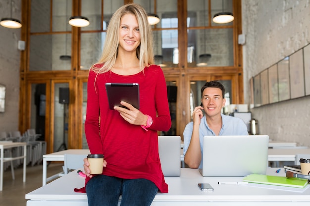 Bezpłatne zdjęcie młodzi atrakcyjni ludzie pracujący razem online w otwartej przestrzeni co-working office room