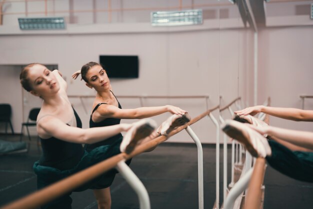 Młodzi klasyczni żeńscy tancerze ćwiczy w tana studiu